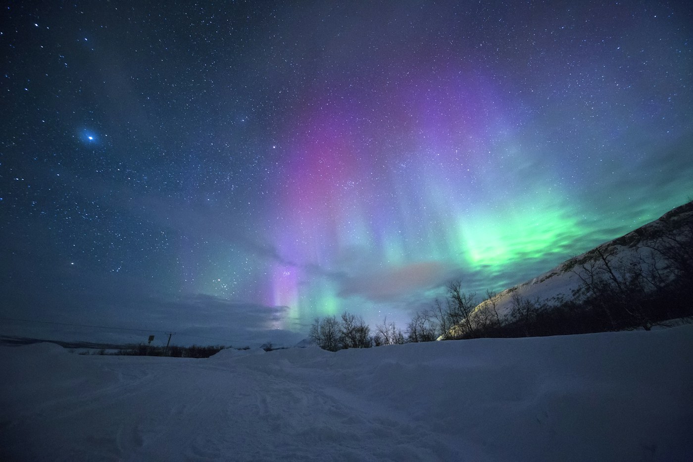Aurora boreal verde sobre uma paisagem nórdica